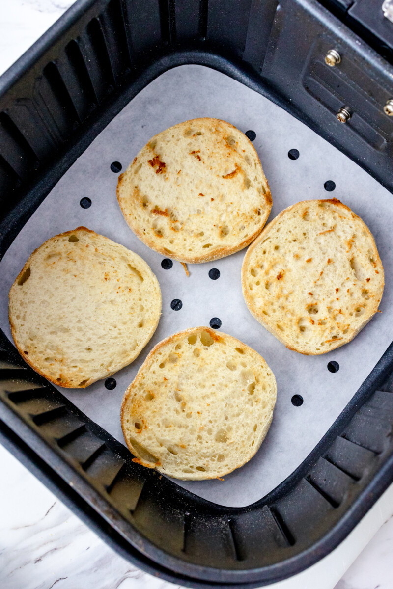 Top view of toasted English muffins in the air fryer.