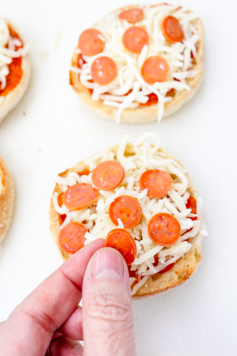 Close up view of pepperoni being added to the muffins.