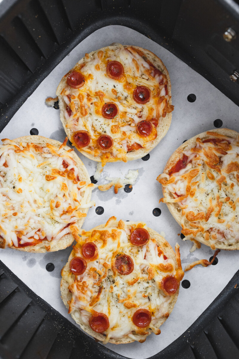 Top view of cooked English Muffin Pizzas in the air fryer.