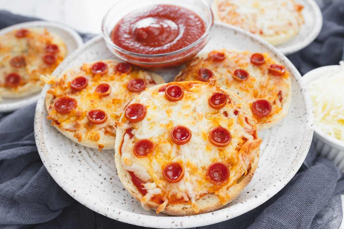 Top view of Close up view of cooked English Muffin Pizzas on a white plate.