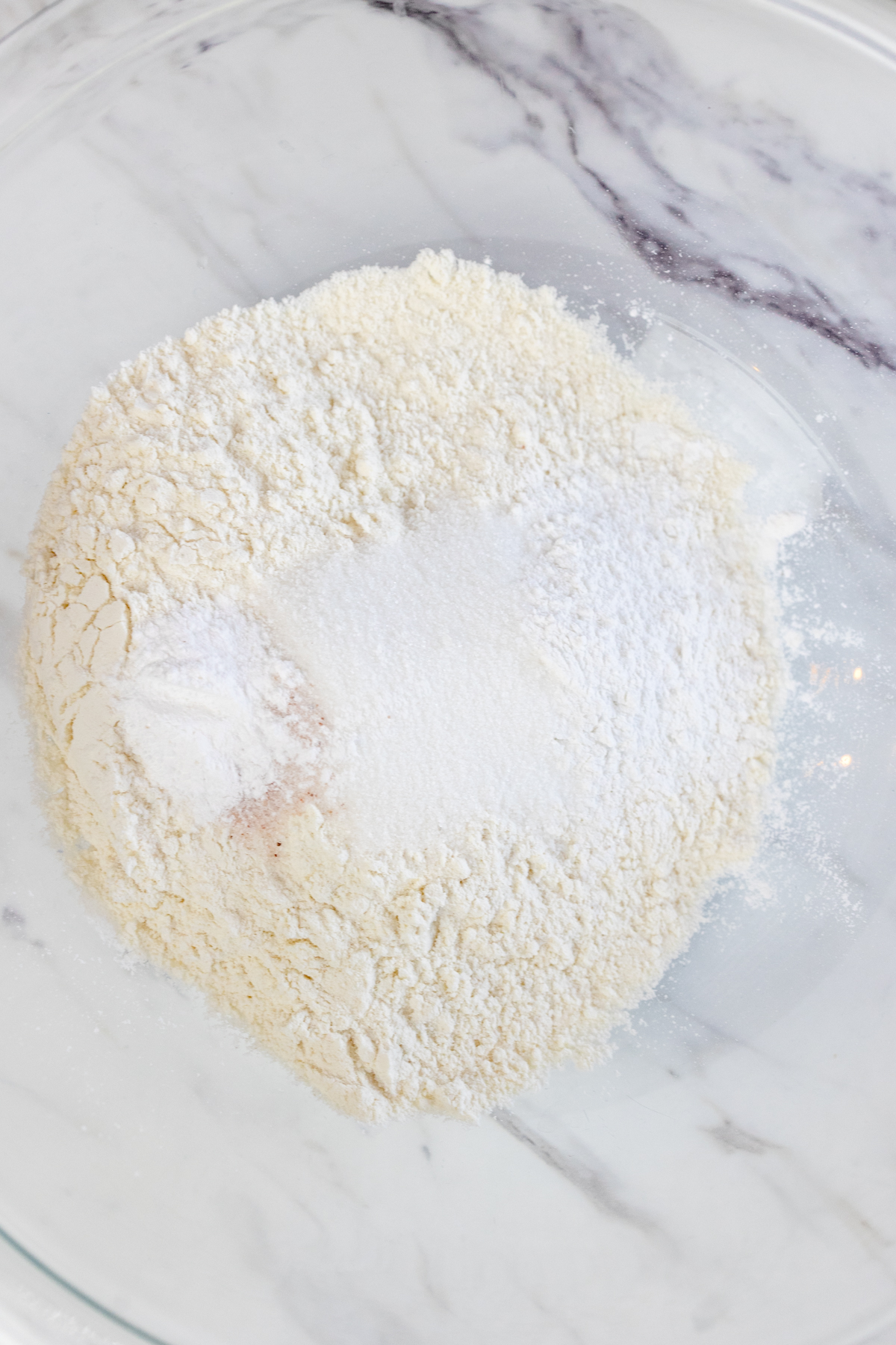 Top view of dry ingredients in a glass mixing bowl.