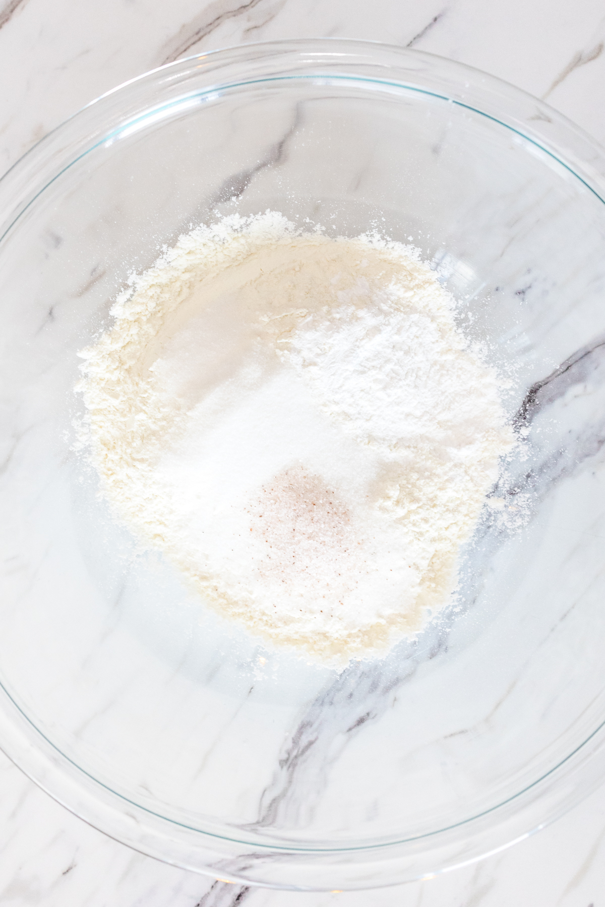 Top view of a large mixing bowl with dry ingredients for butter swim biscuits in it.