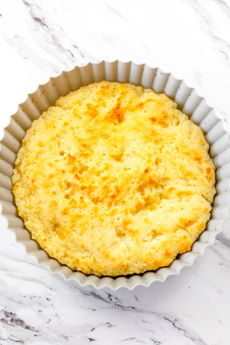 A top view of a silicone baking dish on a white surface with cooked butter swim biscuits in it.