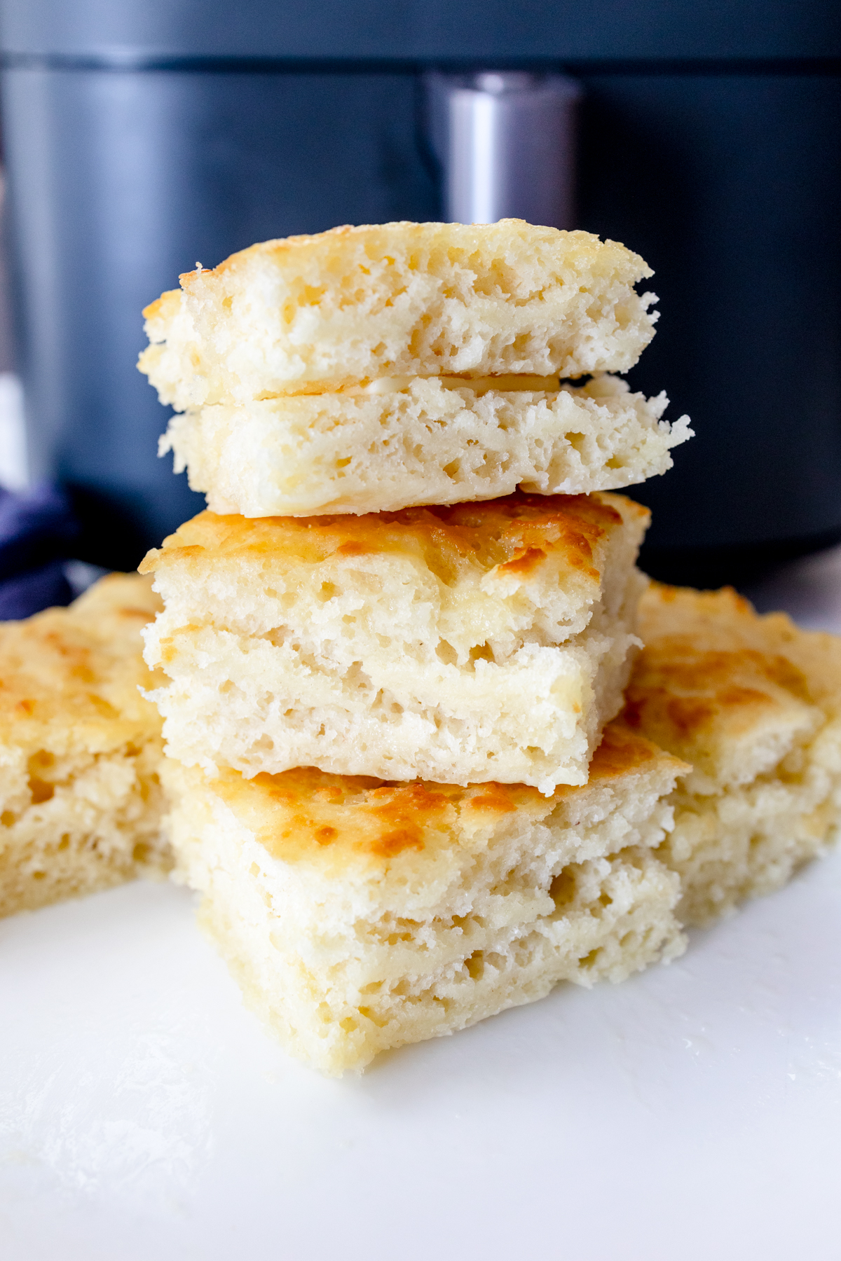 Close up shot of butter swim biscuits in front of an air fryer.