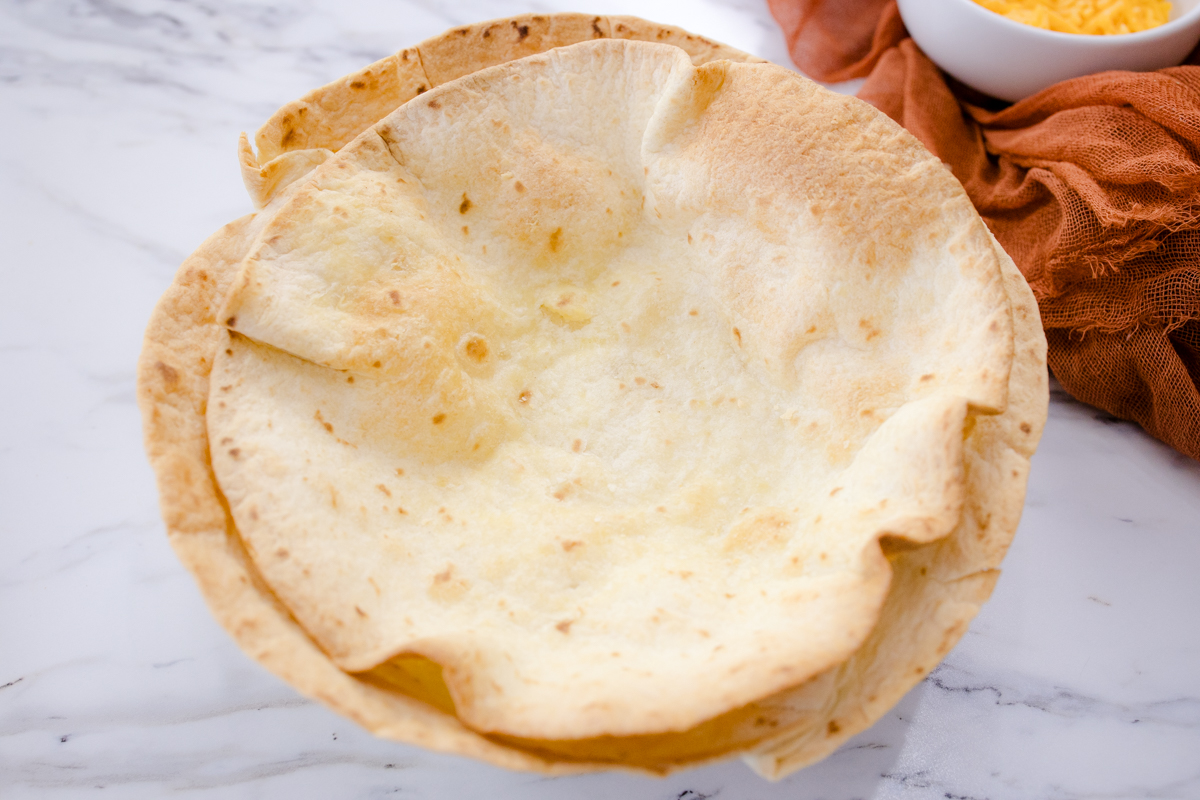 A stack of Air Fryer Flour Tortilla Bowls.