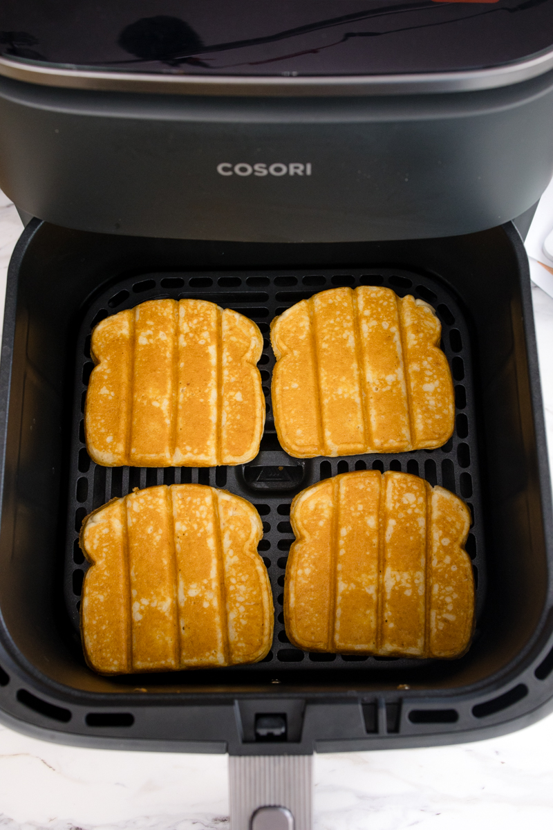 Cooked Air Fryer Frozen French Toast Sticks in an air fryer basket.