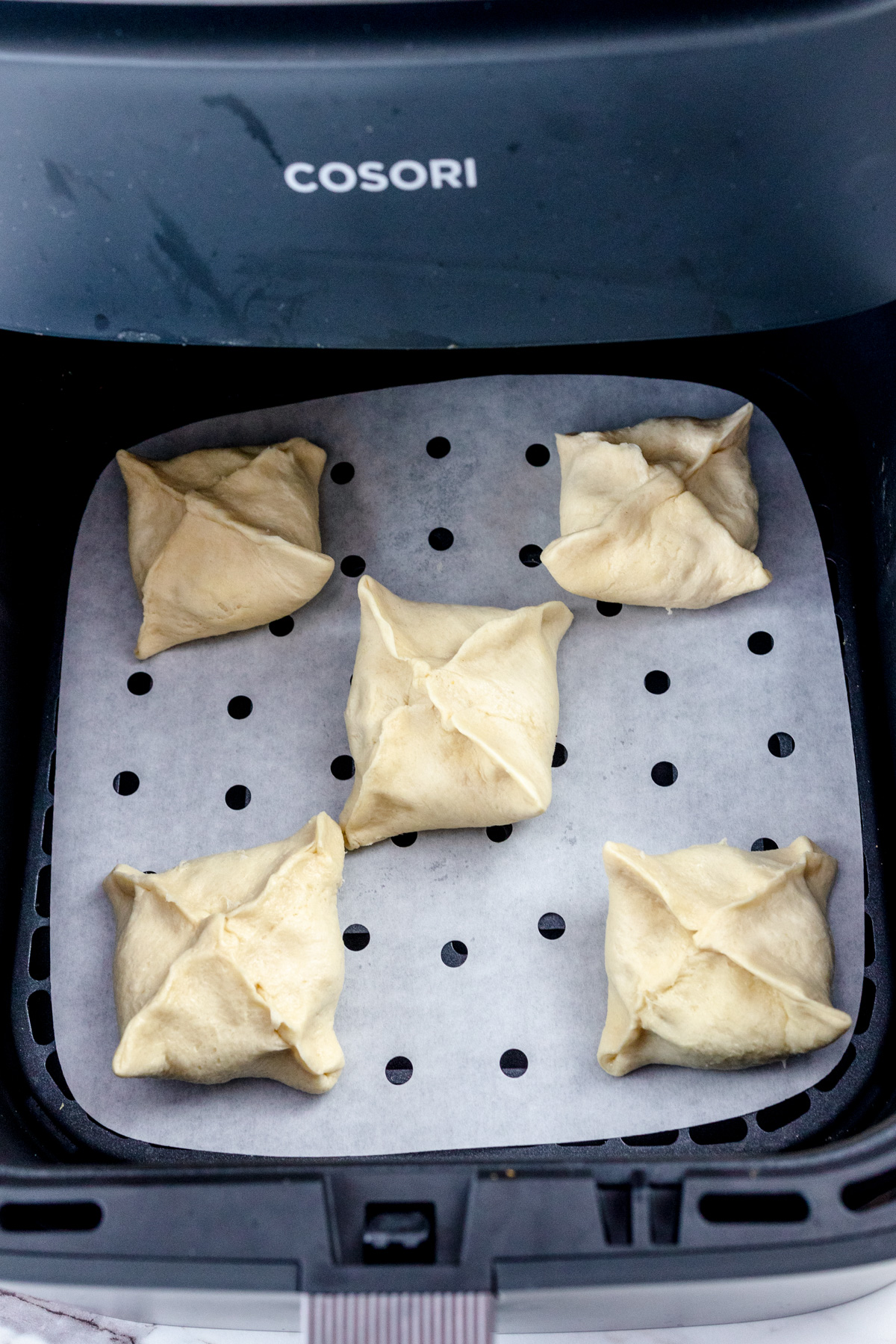 Dough-wrapped oreos in an air fryer basket.