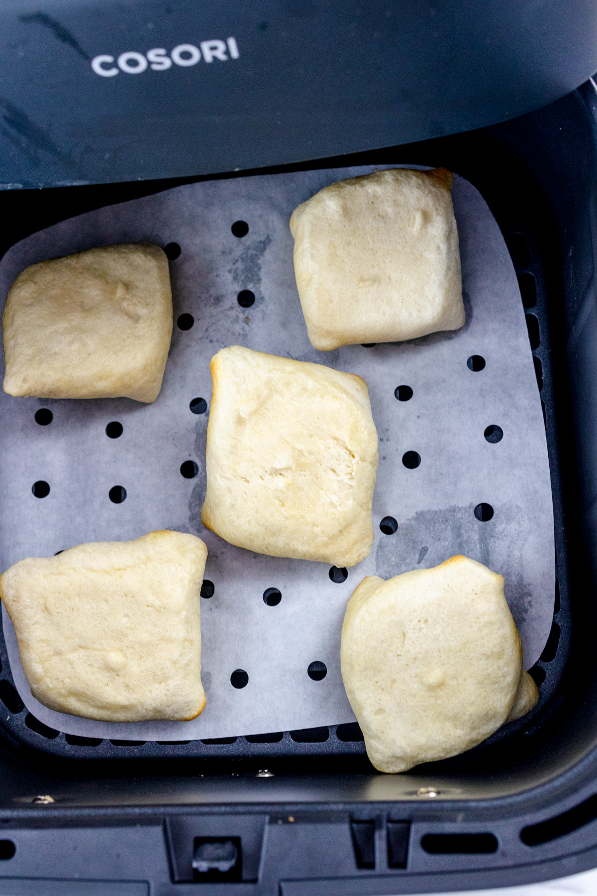 Upside-down dough-wrapped oreos in an air fryer basket.