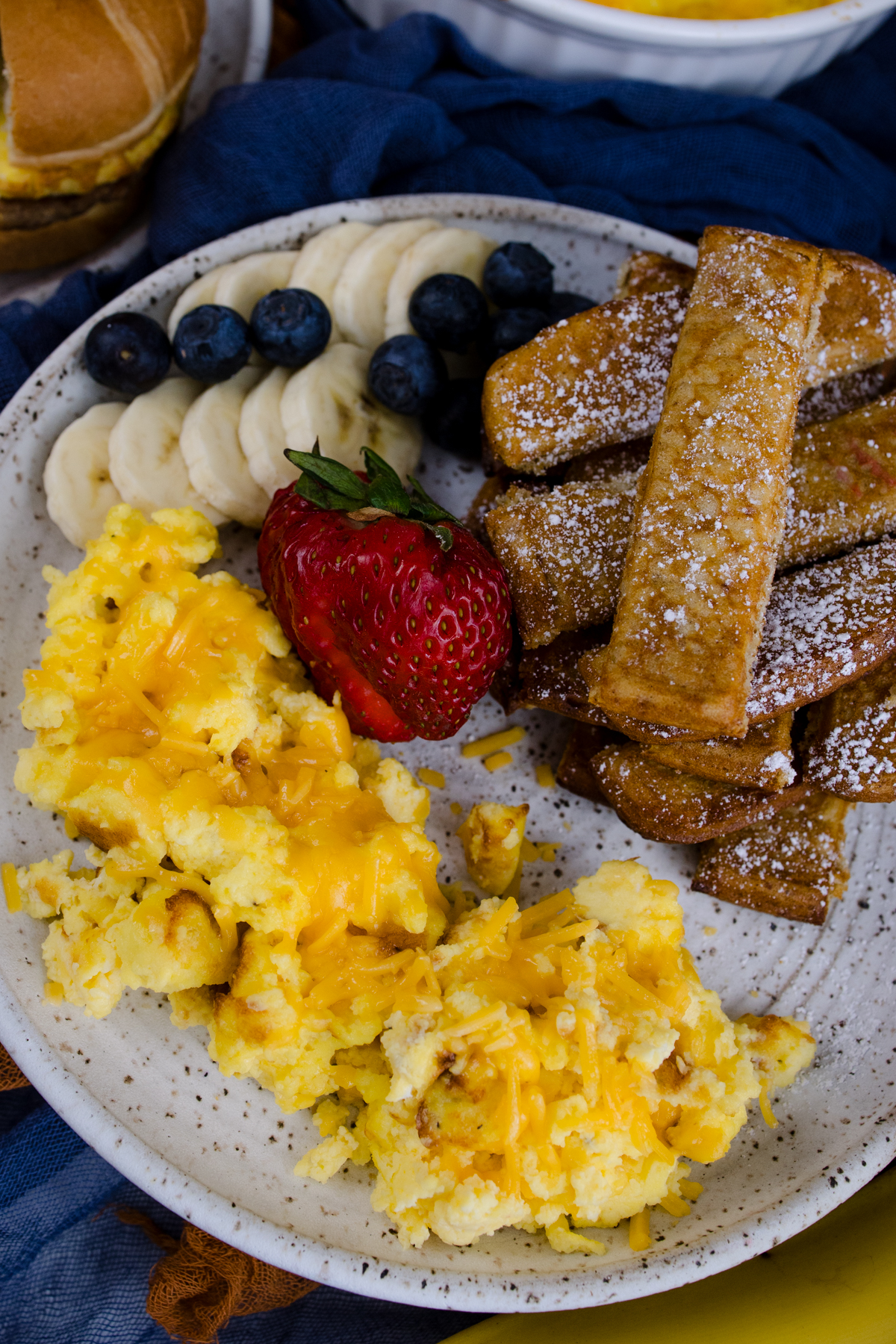 Air Fryer Scrambled Eggs on a white plate with other breakfast items.