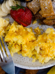 Air Fryer Scrambled Eggs on a white plate with other breakfast items.