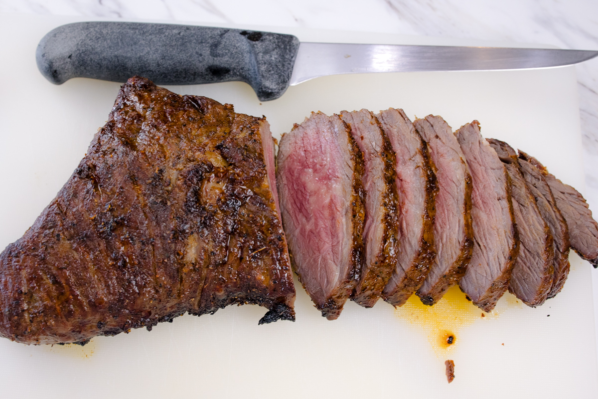 Medium rare Air Fried Tri Tip, in slices with a knife next to them.