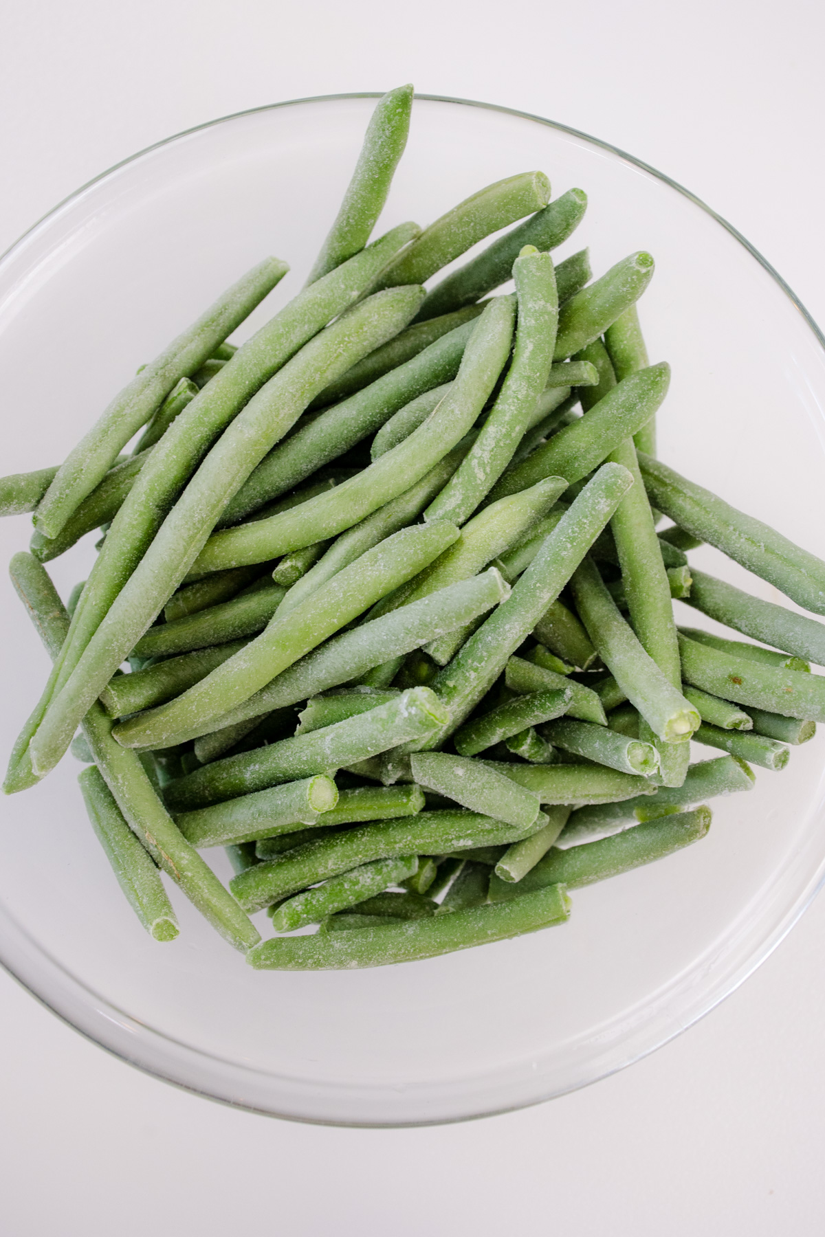 Frozen green beans in a glass dish.