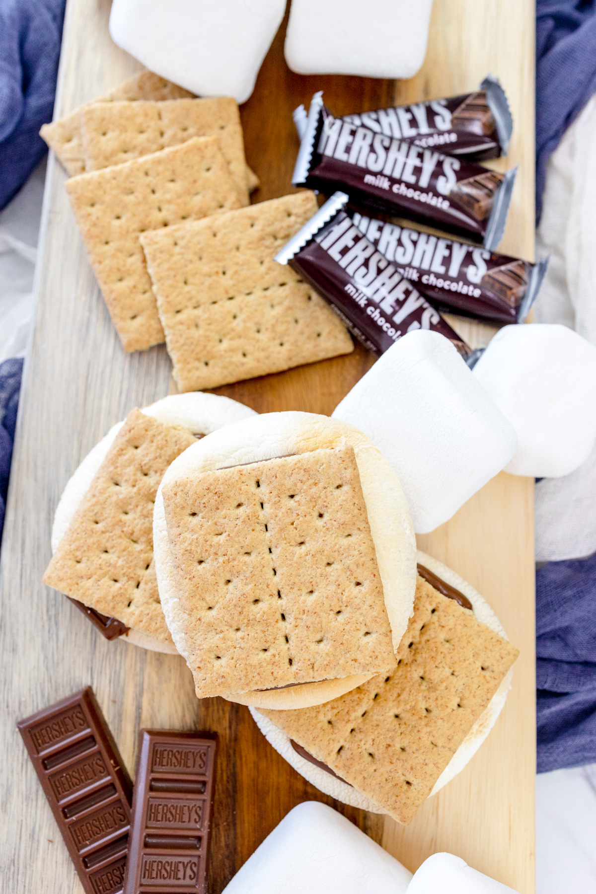 Air Fryer Smores and the ingredients needed to make them on a wooden surface.