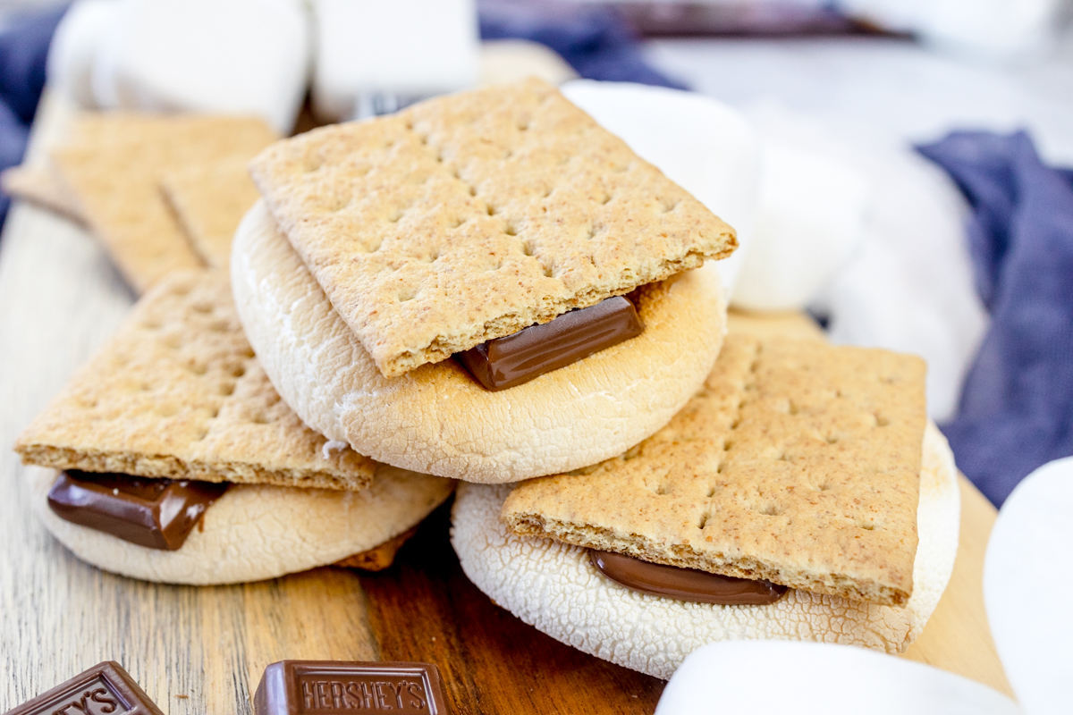 Air Fryer Smores stacked up on a wooden surface.