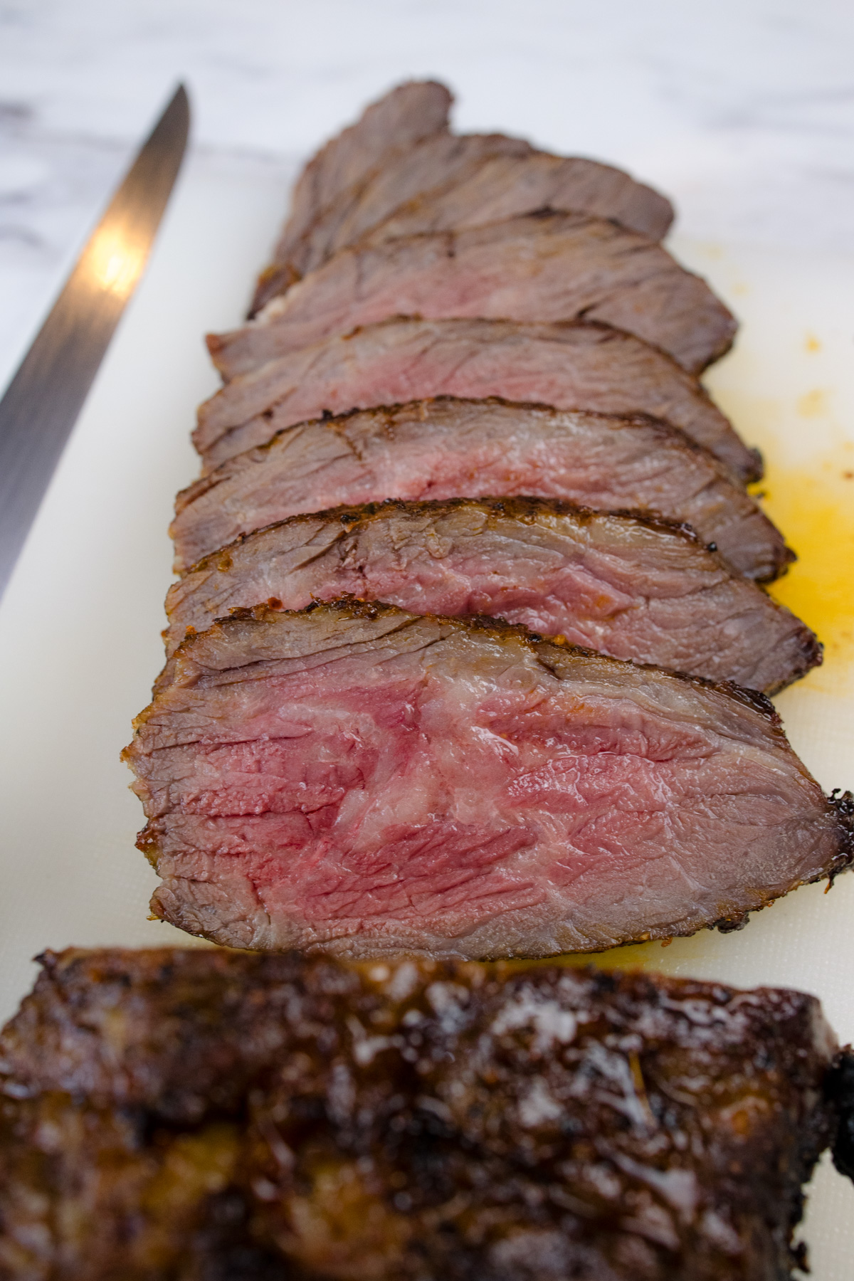 Medium rare Air Fried Tri Tip, in slices with a knife next to them.