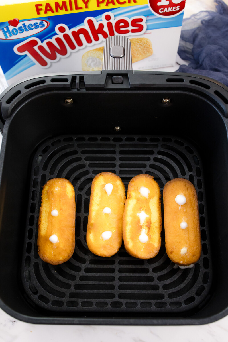 Four upside-down Twinkies in an air fryer basket.